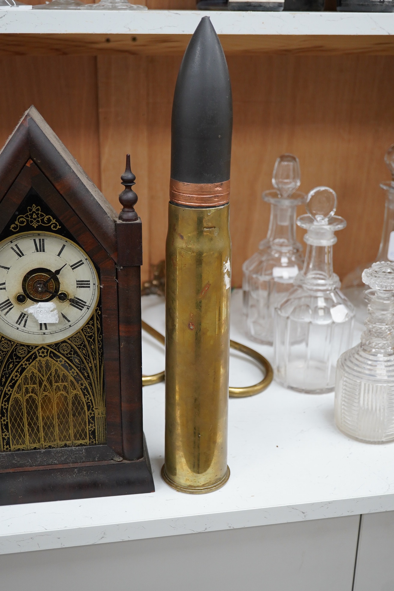 Two clocks including an American example, with keys and two military interest brass shells. Condition - fair